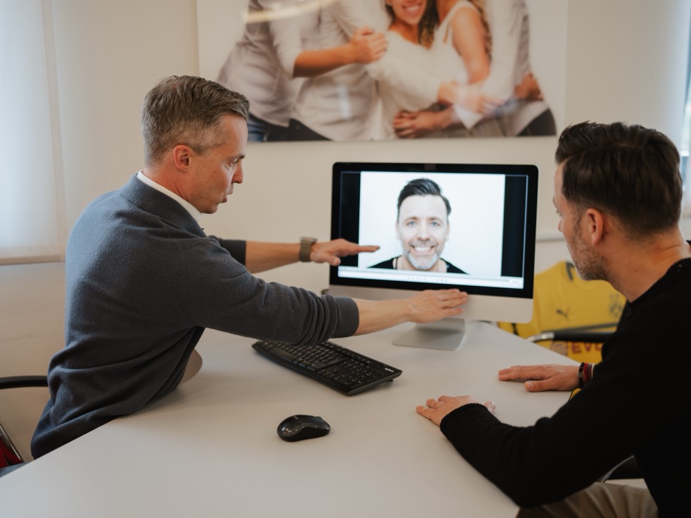 In der Sprechstunde wird einem Patienten sein Foto am Bildschirm erklärt